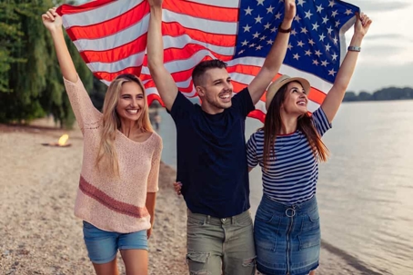 3 students holding the American flag