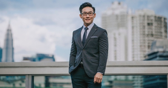 Asian businessman in the foreground with a skyline in the background