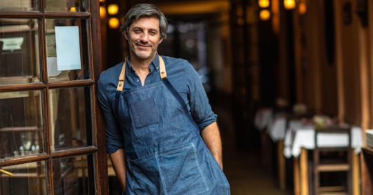 Hispanic business owner opening his business for the day