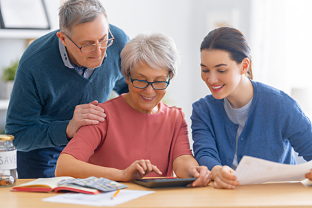 adult child with older parents reviewing documents