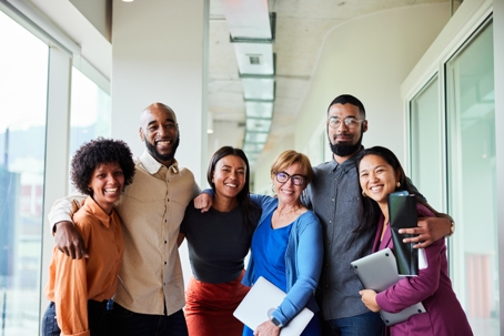 Smiling businesspeople standing arm in arm