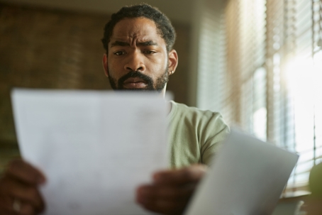 troubled man reading a letter