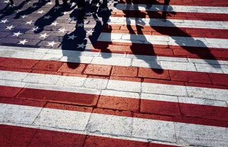 shadows of people walking across american flag pattern